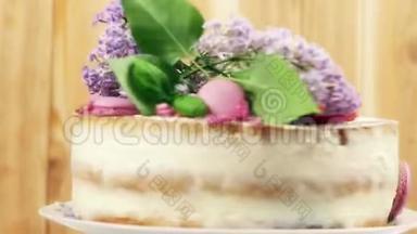旋转婚礼<strong>蛋糕装饰</strong>紫色马卡龙，切片<strong>草莓</strong>和丁香花4K内部拍摄