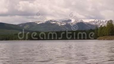 在水面上反射风暴云的山湖景色。 岸上的针叶林