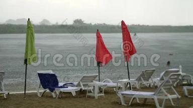 夏雨，雷雨，强降雨在空旷的沙滩上，河边.. 孤独的，空的，空的，阳光的，沙滩伞的