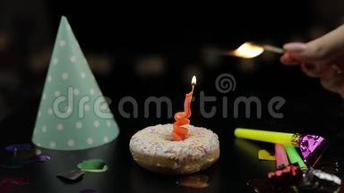 派对。 粉红色的甜甜圈和红色的节日蜡烛在上面。 金色纸屑掉落
