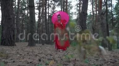 穿着红色和服的神秘女孩带着雨伞和扇子在针叶林中散步，动作缓慢