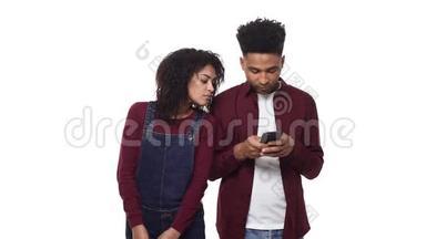 年轻的非裔美国夫妇在约会时玩他们的手机。