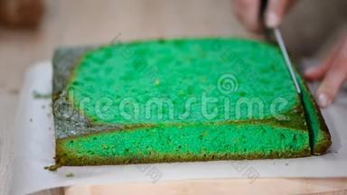 女用手拿刀切绿色海绵蛋糕