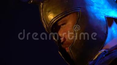 带着沉重头盔严肃表情的汗流浃背的罗马角斗士站在那里，打开摄像机