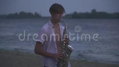 英俊的年轻人正在河岸上吹萨克斯管