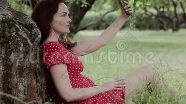 加上<strong>坐在树下</strong>的草地上的大小女孩使用她的智能手机