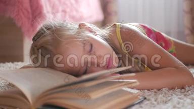 画像悲伤的女学生不想读书读书。一个可爱的金发女孩睡在书上，她累了
