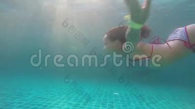 穿比基尼的年轻黑发女子正在水下缓慢地通过阳光游泳。 1920x1080
