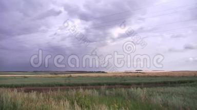 灰蒙蒙的天空下覆盖着干燥的绿草的巨大<strong>田野</strong>景观。 <strong>场景</strong>。 雨前农村的天空乌云密布