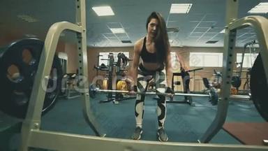 运动健身馆里用杠铃伸展肌肉的美女