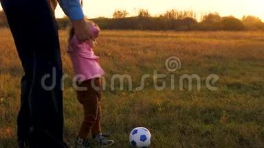快乐爸爸和孩子踢皮球.. 日落时分，一家人在公园里和小宝宝玩足球。 幸福家庭