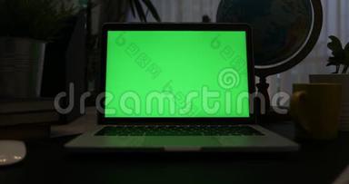 带有绿色屏幕的笔记本电脑。 黑暗的办公室。 多莉出去。 完美地放置你自己的图像或视频。 正在使用的技术绿色屏幕。 <strong>语文</strong>
