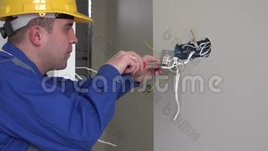 年轻电工与墙壁插座和螺丝刀安装插座