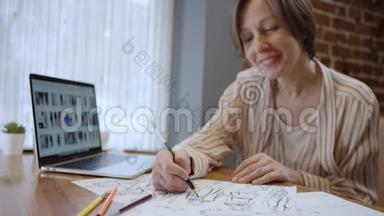 近距离拍摄创意时尚设计师的休闲服装，查看笔记本电脑和绘制草图。 两个女人