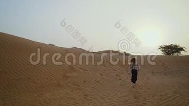 漂亮的女孩在沙漠里奔跑。 美丽的女人在日落时奔跑。 慢动作