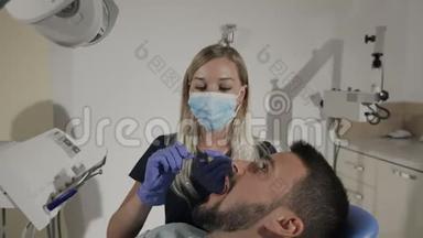 女牙医用口腔镜和牙科挖掘机检查病人牙齿
