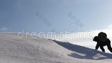 登山者手牵手爬到雪山顶上。 冬天的旅行者团队要达到克服困难的目标