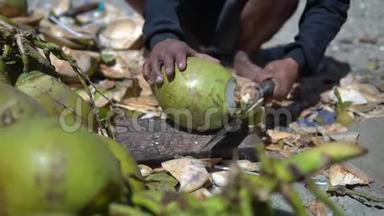 土著男子用大<strong>砍刀</strong>切椰子，以获得一个年轻椰子的美味果汁，当地的驼背人下来和排骨