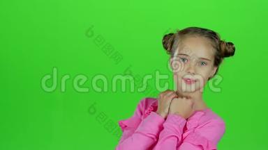 小女孩竖起大拇指，做鬼脸。 绿色屏幕