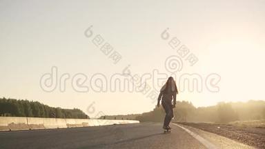 日落时分，女孩在一条荒芜的公路上的滑板上滑冰。 青年亚<strong>文化</strong>。 慢动作