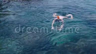 热带海洋中的年轻女子浮潜和用<strong>手机制作</strong>水下照片视频