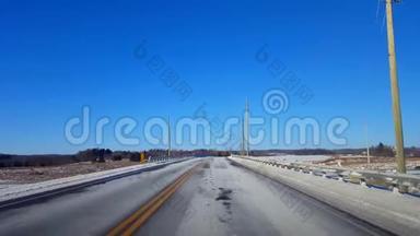 <strong>白天</strong>驾驶冬季农村公路。 司机的观点POV乡村<strong>街道</strong>与雪