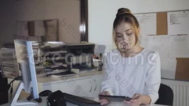 年轻的女青少年在<strong>办公室</strong>里<strong>用电脑</strong>和平板<strong>电脑</strong>工作。 4K