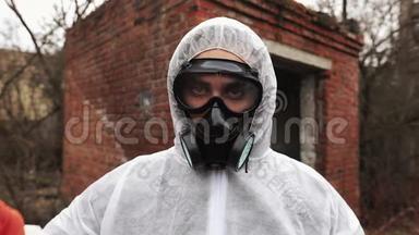 穿着生物危险服和防毒面具的人直视着摄像机