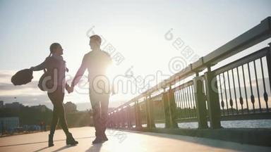 幸福的爱人——男孩和女孩——在日落时分沿着长廊散步