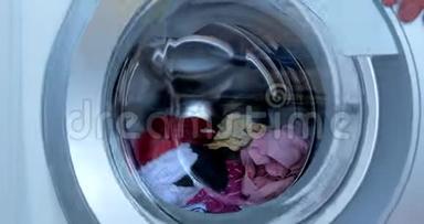 关闭工业洗衣机洗涤彩色服装和白色亚麻，白色条纹服装。 气缸旋转