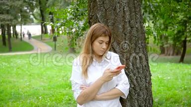 女孩在夏季公园使用智能手机