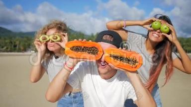 三个有趣的朋友愚弄周围与异国热带水果。 素食健康饮食。 泰国范甘。 高清慢速运动。
