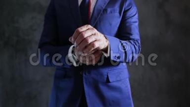 优雅时尚的男士套装，将袖子、订婚戒指和手表对准灰色墙壁