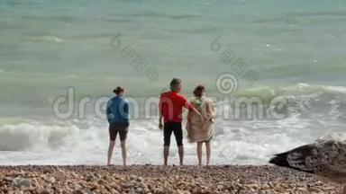 英国布莱顿。 三个暑假的小学生站在靠近大西洋的海滩上。 朋友