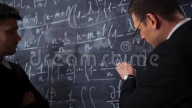 两位科学家<strong>在黑板上写字</strong>，讨论数学方程式和公式。