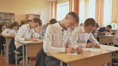 俄罗斯学校。 小学生在笔记本上写控制考试。