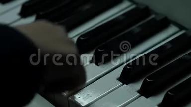在特写镜头中手拿钢琴钥匙。 孩子们学习弹钢琴。 慢动作
