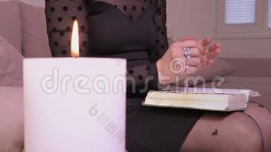 女人在燃烧的<strong>蜡烛</strong>旁读圣经<strong>祈祷</strong>