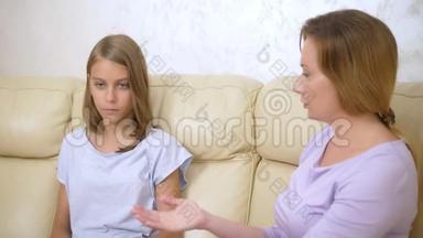 家庭支持和信任的概念.. 妈妈拥抱并安慰坐在客厅沙发上的十几岁的女儿