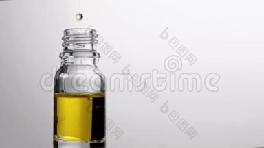 玻璃瓶与吸管精油滴在缓慢的运动。 自然疗法