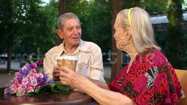 爷爷和奶奶在户外的咖啡馆里喝茶