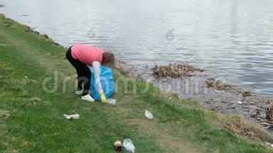 女志愿者清理河边的垃圾.. 在户外捡垃圾。 生态和环境概念