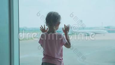 小女孩看着窗外的飞机，后面。