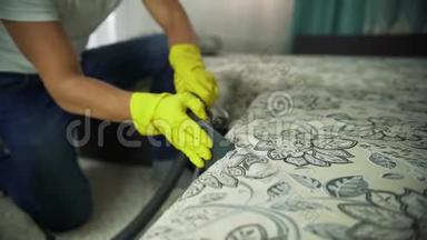 一个清洁公司的人在打扫沙发。 男士统一沙发清洁布配干蒸汽清洁剂..