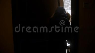 慢镜头视频欢快的女孩打开房门，跑出来的后院覆盖着雪
