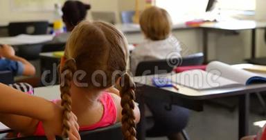 高加索女学生在学校4k教室里坐在课桌前的后视镜