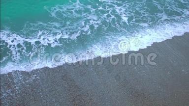 绿色泡沫的海浪<strong>上岸</strong>，缓慢地溅在沙滩上