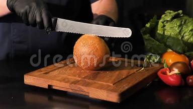 在<strong>木板</strong>上用菜刀切面包，<strong>背景黑色</strong>