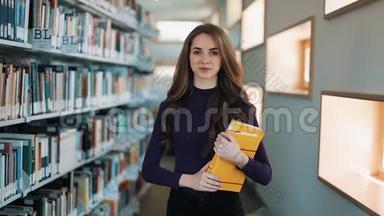 留着长发的女孩微笑着，直视着图书馆<strong>书架前</strong>的镜头