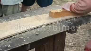 中世纪棉衣匠用木板工作. 手动修一个木板